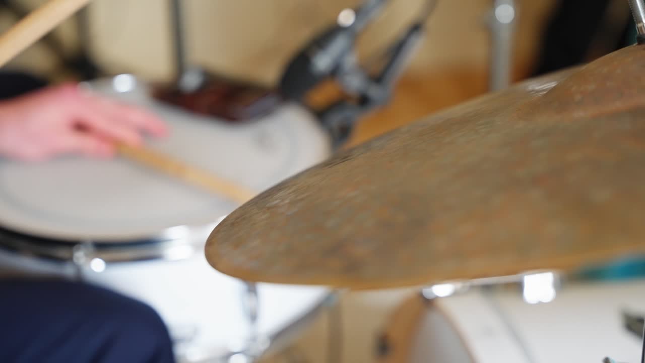 Drumsticks hitting snare drum and cymbals in slow motion showing bouncing rhythm and closeup impact