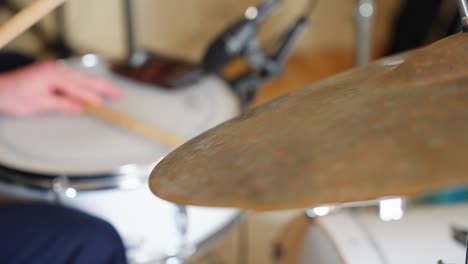 drumsticks hitting snare drum and cymbals in slow motion showing bouncing rhythm and closeup impact
