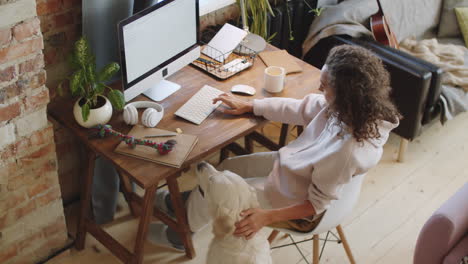 mujer trabajando desde casa con su perro