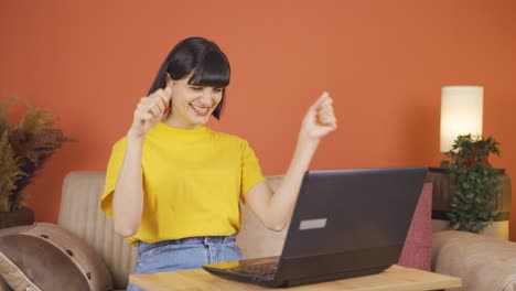 la mujer mira la computadora portátil y se alegra.