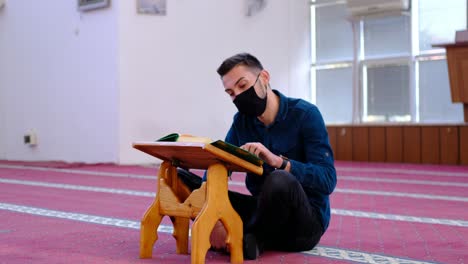 Hombre-Con-Máscara-Leyendo-El-Corán-En-La-Mezquita.