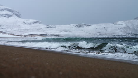 Stormy-cold-winter-waves,-snowing-and-heavy-wind-at-Norway-Ervik-beach,-vestkapp