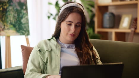 mujer joven trabajando en una computadora portátil en casa