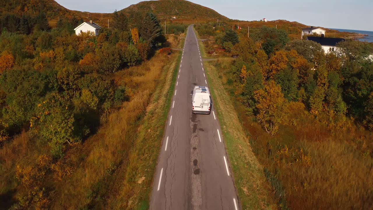Driving through the scenic Vestarelen region in Norway, surrounded by autumn foliage and a clear road