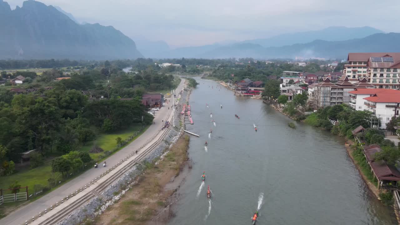 Veduta aerea del fiume Nam Song a Vang Vieng con barche lunghe che passano.