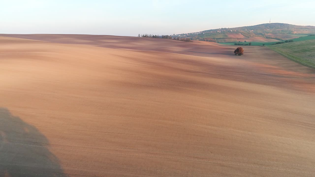 Wide angle dolly in drone shot of dry land in the eastern part of the Czech Republic in Moravia during the day