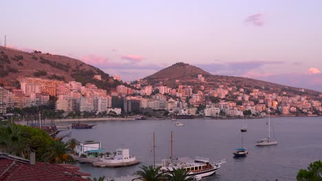 Slow-pan-across-calm-sunset-scenery-at-stunning-and-vibrant-coastal-town-with-boats