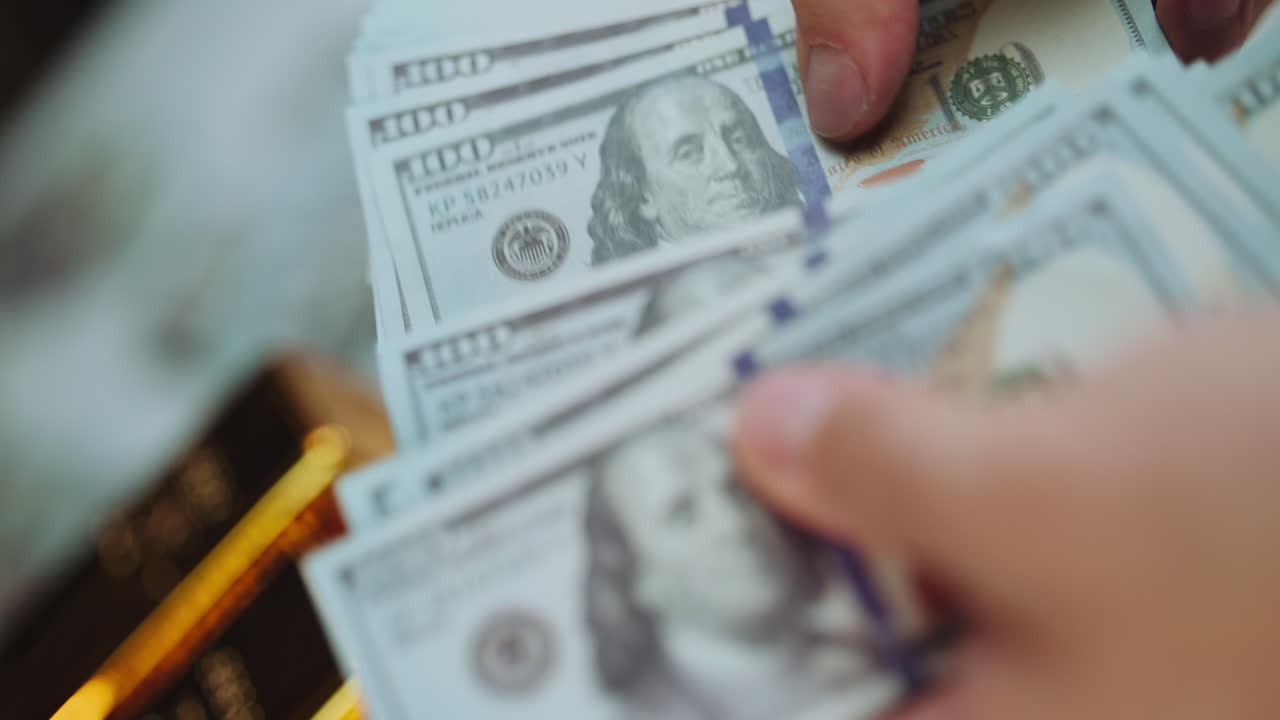 Stack of hundred dollar bills and gold bars