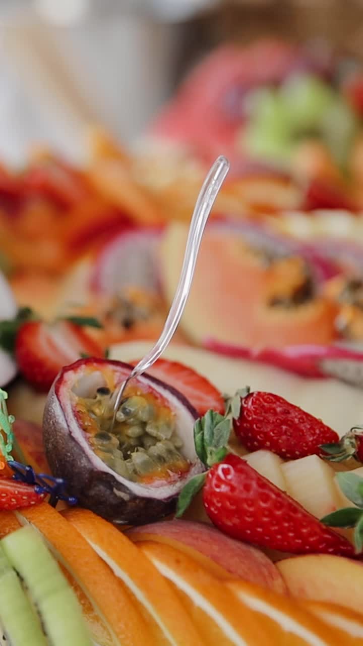 Beautifully decorated catering platter displaying a variety of fresh exotic fruits, ready to be served. Vertical video