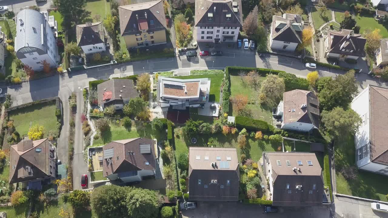 Houses, buildings, roads and garden in a residential area, neighbourhood Lausanne, the capital city in Vaud, Switzerland, drone aerial view, tilt up