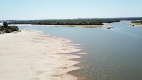 Drone-Descendiendo-Sobre-Un-Río-En-Estación-Seca-En-Un-Día-Soleado