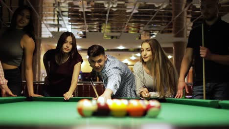 friends joyfully play billiards.