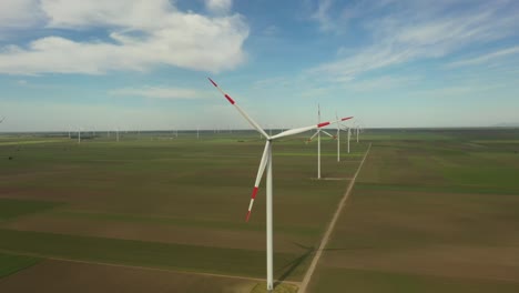 view of several windmills, wind generators, turbines, producing renewable clean energy by converting kinetic energy