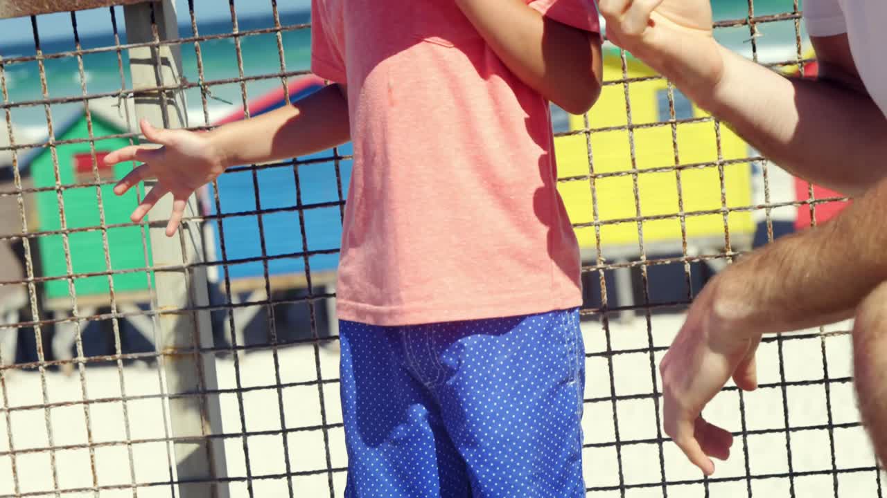 아버지와 아들이 해변에서 아이스크림을 먹고 있습니다.