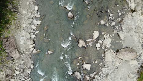 Top-down-aerial-view-of-pristine-river-rapids-flowing-over-boulders