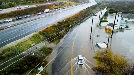 Un-Dron-Se-Eleva-Por-Encima-De-Los-Autos-Que-Dan-Vuelta-Después-De-Ver-Una-Carretera-Inundada-Bloqueando-El-Camino.