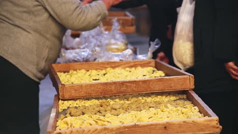 handmade pasta preparation and distribution at a local market