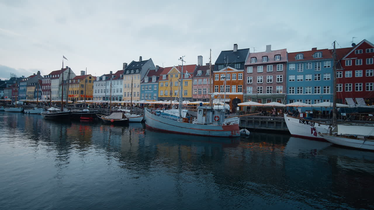 Bredt, statisk skud af Nyhavn havn i København tidlig morgen, farverige bygninger ved vandet spejlet i det rolige vand del 3.