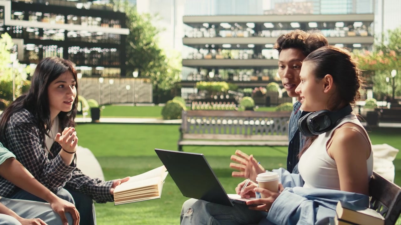 Woman student gestures while discussing project notes with classmates
