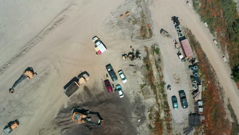 aerial descending toward vehicles and heavy equipment at a construction site