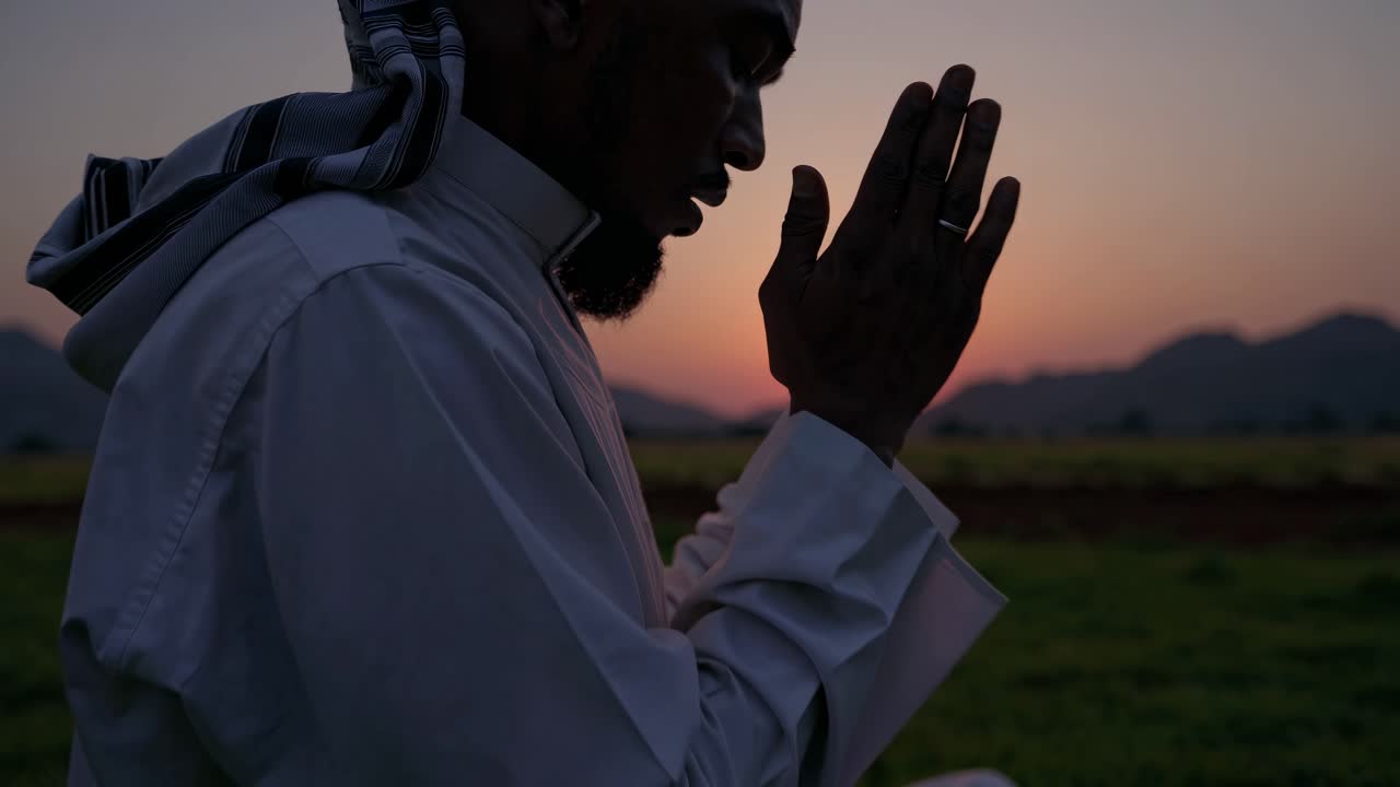 일몰 때 기도 하는 무슬림 남자