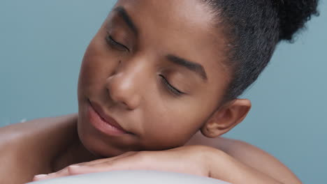 close up portrait beautiful young african american woman relaxing feathers falling on soft natural skin gently caressing healthy complexion in slow motion skincare concept