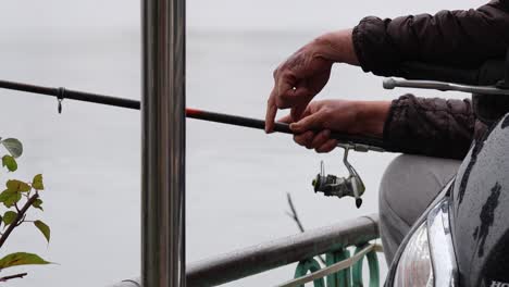 man fishing with rod by riverside