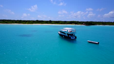 touristic boat anchored at the turquoise waters of a tropical island, circular move drone footage