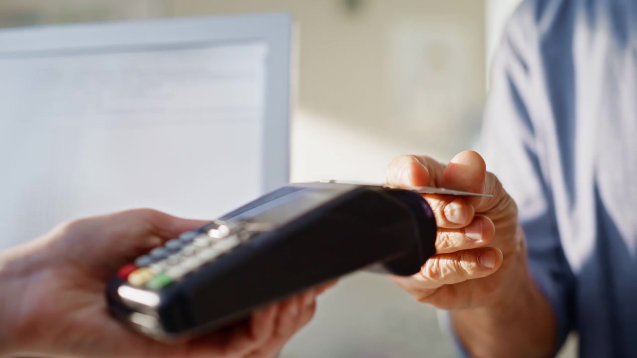 Commesso di farmacia che consegna il terminale al cliente, primo piano. Uomo che paga.