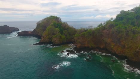 stationary aerial shot overlooking a rugged bay of water and mountains off tortuga islands in costa rica