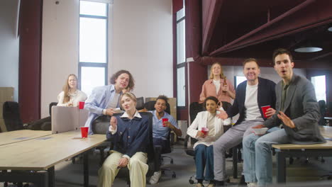 grupo de colegas multiétnicos viendo un partido deportivo, animando y apoyando a su equipo en la oficina 4