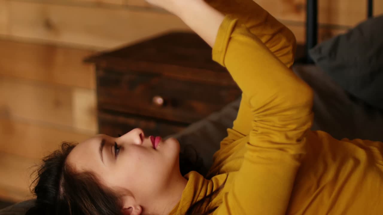 mujer usando teléfono móvil en la cama