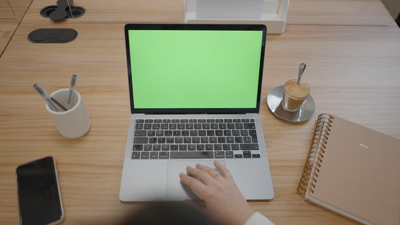 Person working on a laptop at a modern office desk