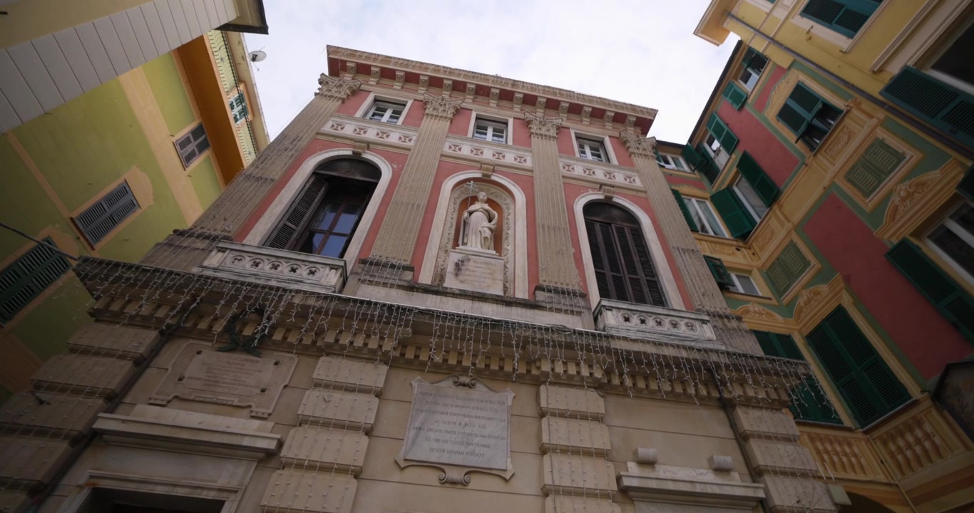 Facciata di edificio storico con una statua circondata da una vivace architettura tradizionale italiana
