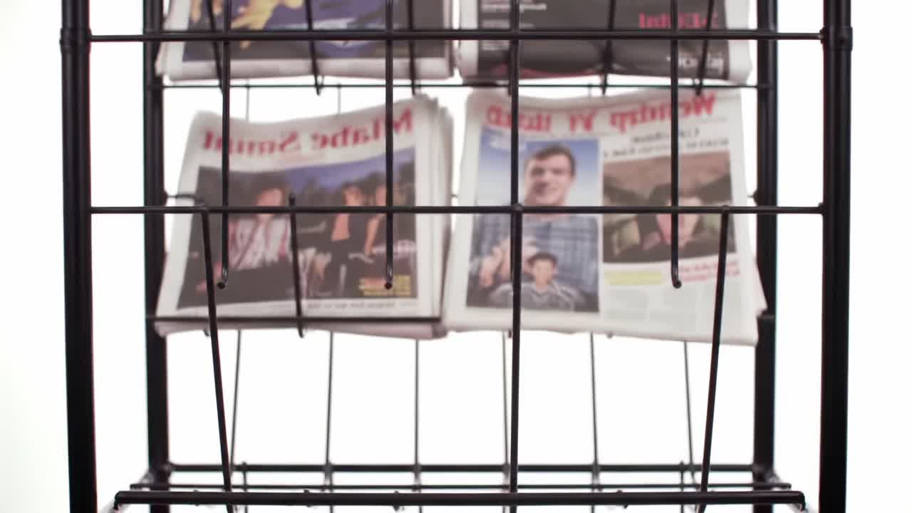 A Display of Newspapers Organized in a Rack Showcasing Various Headlines and Themes, Representing Diverse News Coverage and Print Media Presentation