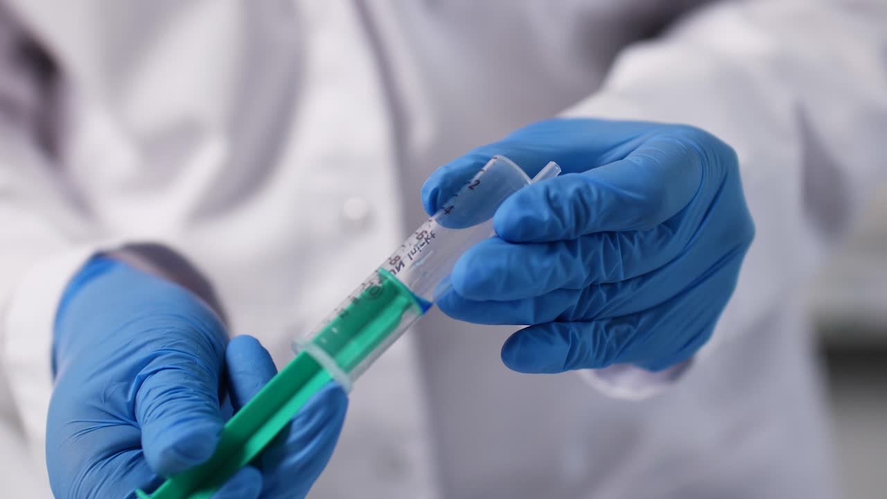 una jeringa es mostrada por un asistente de medicina