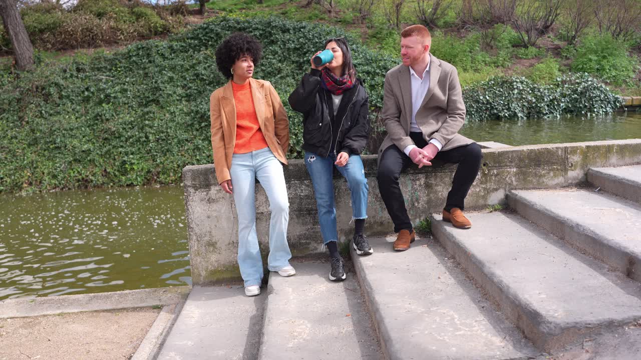 Des gens assis discutant au bord du canal dans un parc