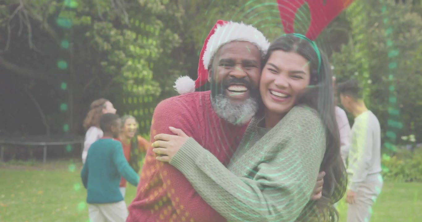 Pareja entrando a un jardín, abrazándose, riendo con copos de nieve animados alrededor para un saludo navideño.