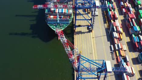 container ship loading at port with crane, container ship carrying container import and export business logistic and transportation, aerial top view