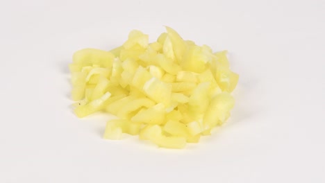 pimienta amarilla en cubitos. concepto de alimentos saludables. preparación de verduras para ensalada. movimiento de bucle. vista lateral. rotación 360.
