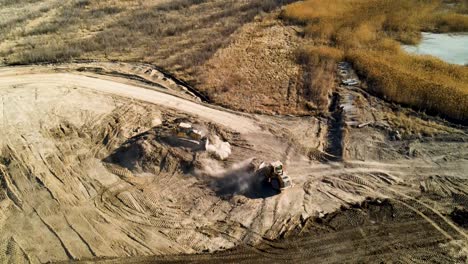 bulldozers moving mounds of dirt on a large construction site - aerial view