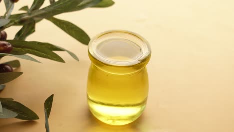 aceite de oliva en botella de vidrio con rama de olivo
