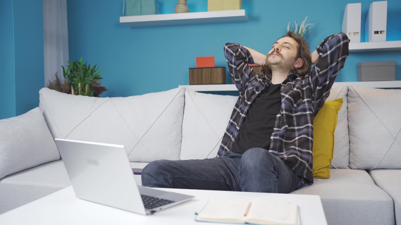мужчина работает на ноутбуке дома. счастлив и доволен.