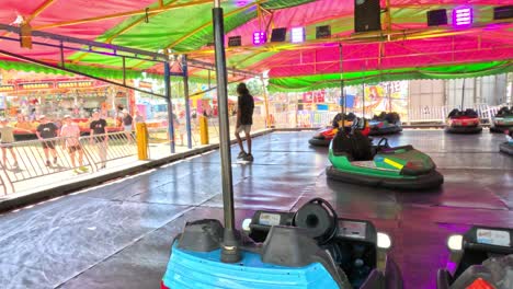 colorful bumper cars moving in an indoor arena