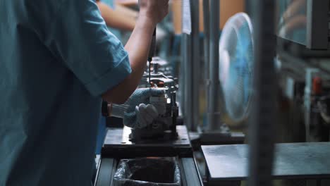 ingeniero de atornillado de pernos en aparatos metálicos en la línea de montaje en la fábrica