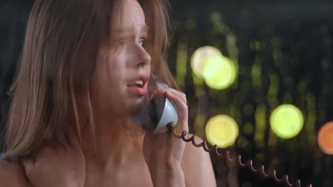young woman on an emotional phone call with bokeh lights background