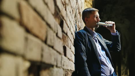man in suit drinking alcohol in back alley addiction concept