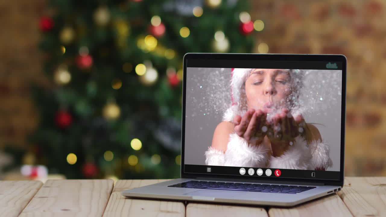 mujer caucásica feliz en disfraz de papá noel en una computadora portátil, con árbol de navidad
