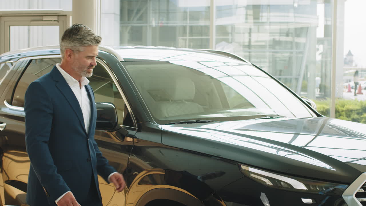 hombre mirando un coche en una sala de exposiciones