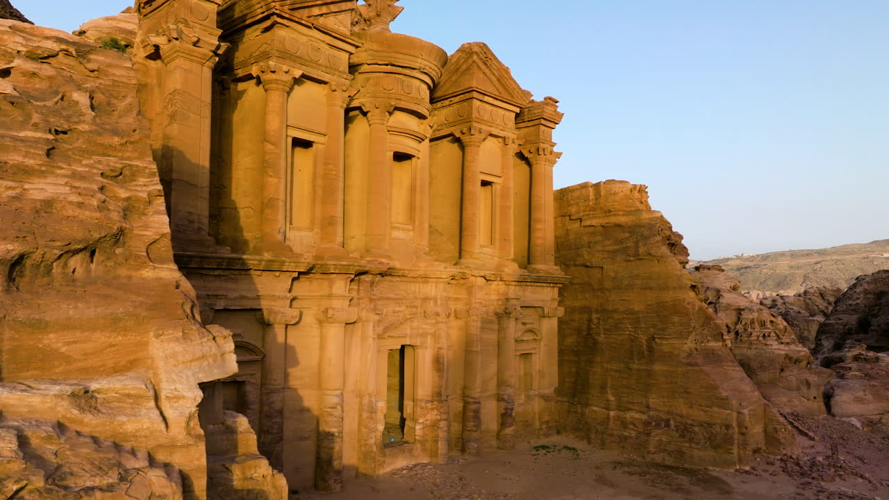 fachada exterior del monasterio de ad deir iluminada por el sol durante la hora dorada en petra, jordania
